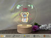 a teddy bear on a clear acrylic with a wooden base