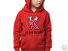 a young boy wearing a red hoodie with the letter k on it